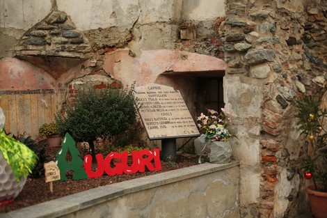 Lapide commemorativa per i caduti partigiani e civili, con decorazioni floreali e messaggi di ricordo.