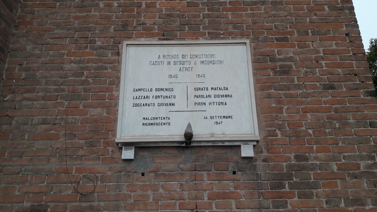 Lapide commemorativa in memoria delle vittime di bombardamenti, con nomi incisi in onore dei caduti.