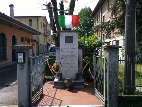 Cippo commemorativo dedicato a Scaltriti, Zavaroni e Gasparini, con bandiera italiana e decorazioni floreali.