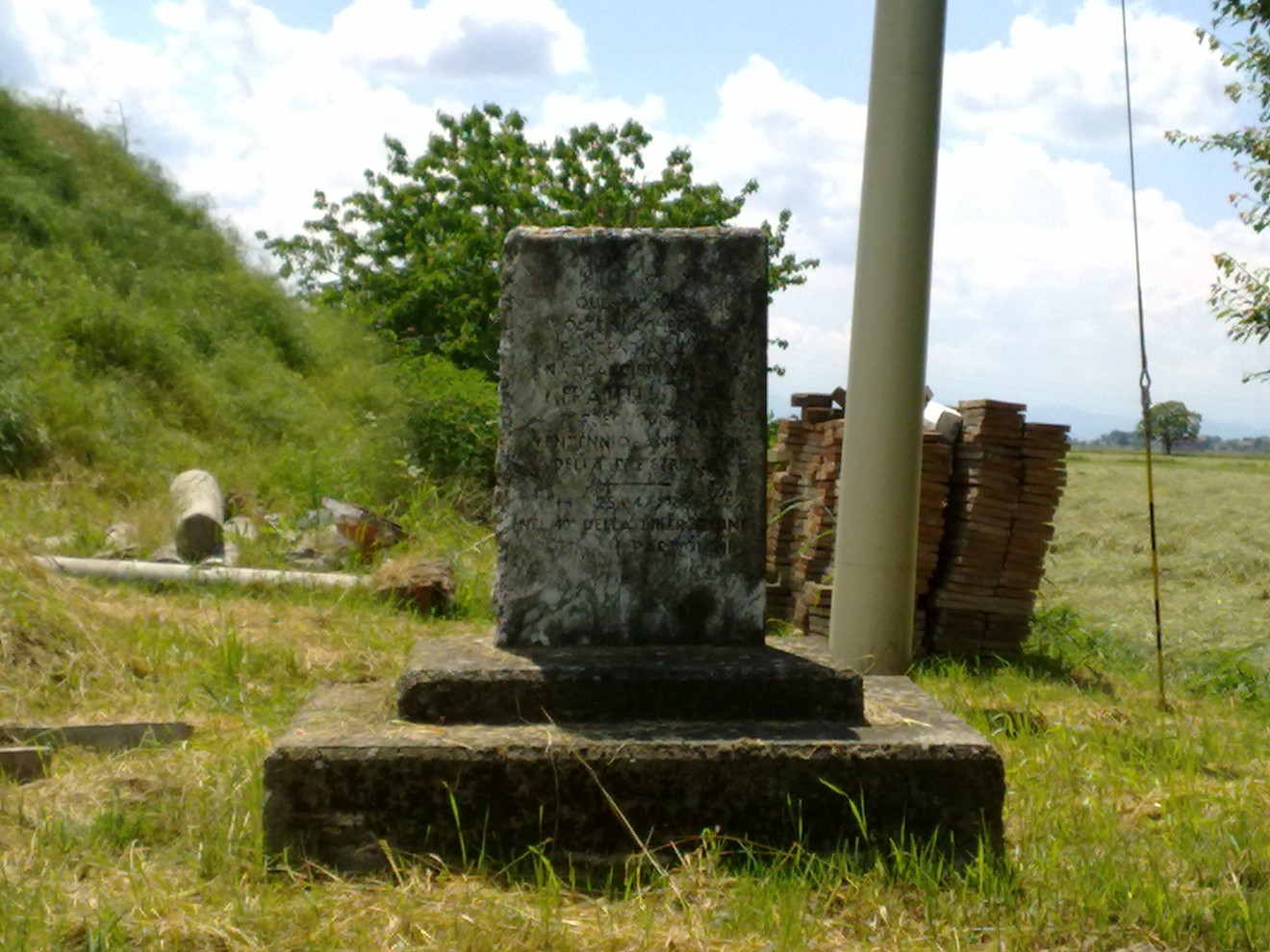 Monumento commemorativo dedicato ai fratelli Poli, immerso in un paesaggio naturale.