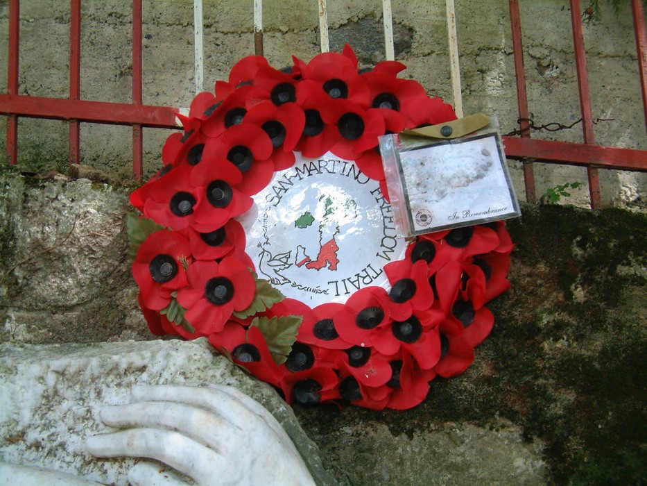 Fiori rossi adornano il Monumento di Mandrione, simbolo di commemorazione e riconoscenza.