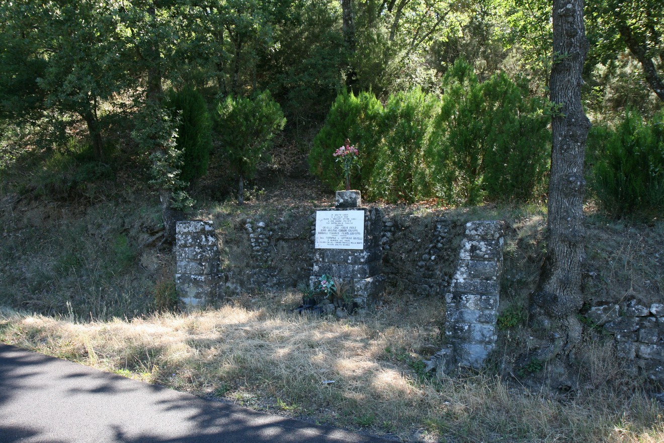 Monumento de La Grotta, un luogo di memoria immerso nella natura, circondato da vegetazione.