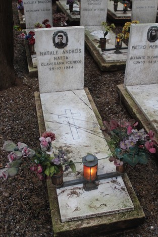 Tombe con lapidi bianche decorate da fiori e candele, commemorano i caduti per la Libertà.