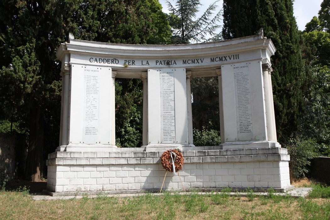 Monumento ai Caduti, un memoriale con iscrizioni commemorative, circondato da alberi e natura.