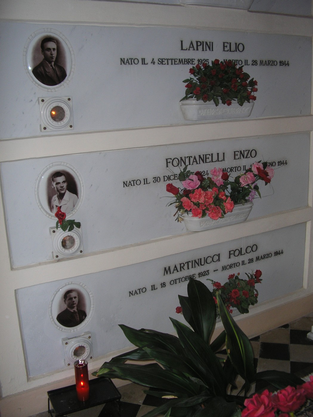Cappella dei partigiani con lastre commemorative e fiori, onorando i caduti della resistenza.