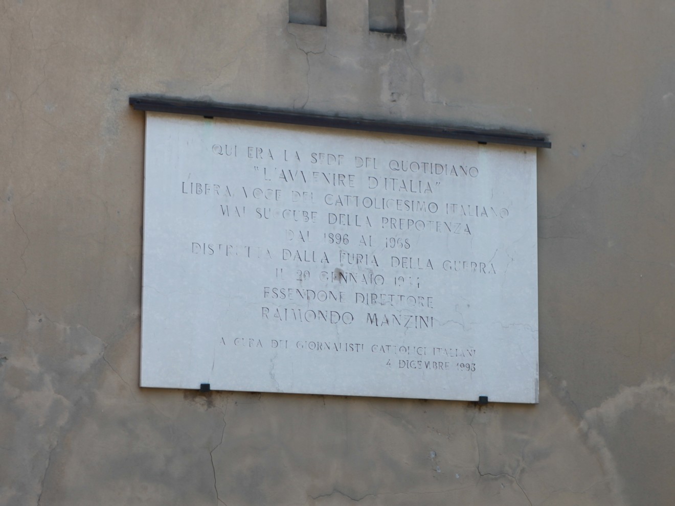 Lapide commemorativa dedicata alla sede del quotidiano Avvenire, con dettagli storici e dati significativi.