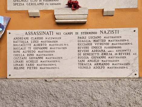 Lapidi commemorative dedicati ai caduti per la libertà, con nomi e date incisi su una superficie di pietra.