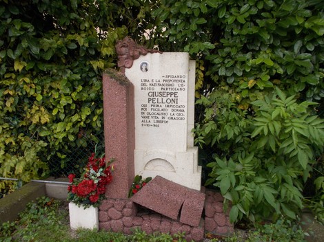 Monumento a Pelloni, commemorazione con iscrizioni e decorazioni floreali. Un tributo alla memoria.