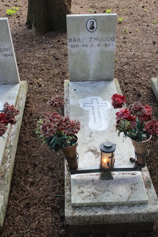 Tombe perpetue decorate con fiori, in memoria di caduti per la Libertà. Atmosfera di rispetto e ricordo.