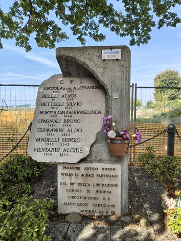 Monumento commemorativo dedicato ai caduti per la libertà, situato a Paganine. Fiori adornano la base.