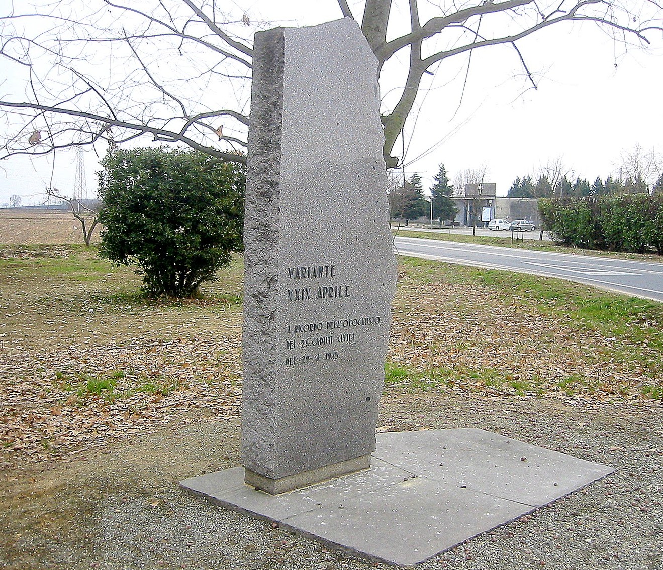 Stele commemorativa in pietra dedicata ai caduti del 29 aprile, situata in un'area rurale.