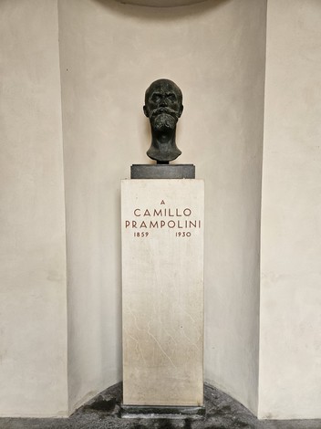Busto in bronzo di Camillo Prampolini su base in marmo, collocato in un ambiente minimalista.
