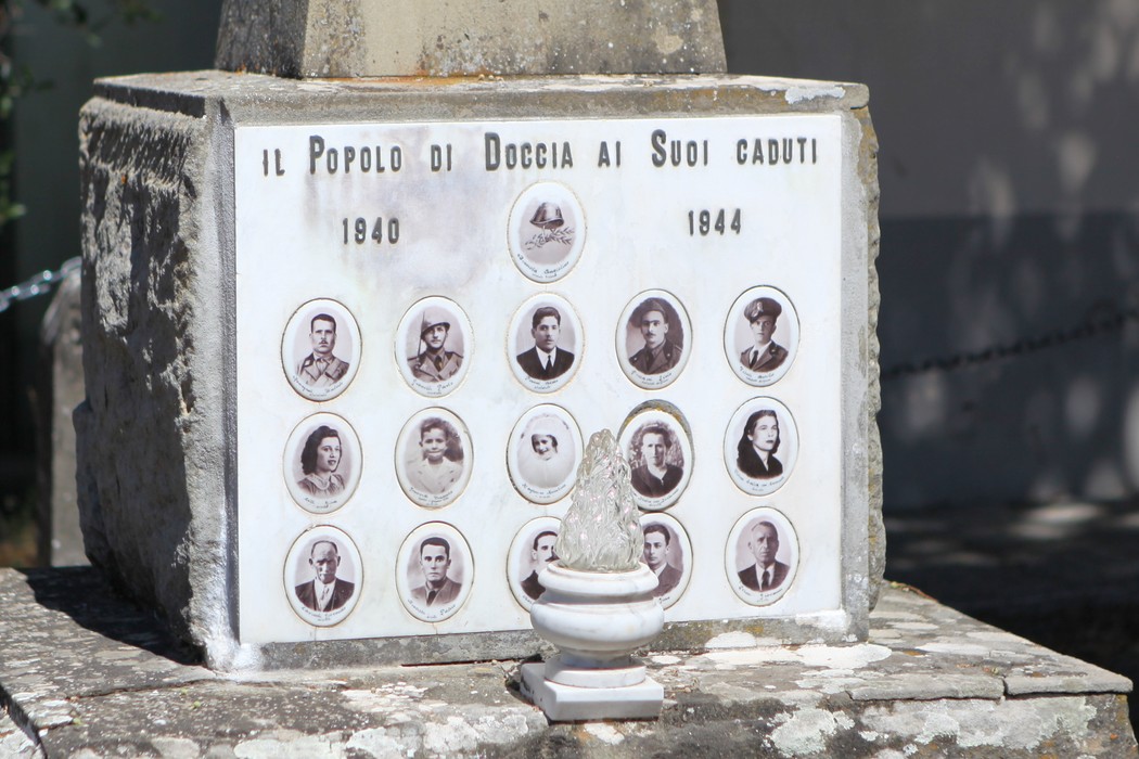 Cippo commemorativo dedicato ai caduti di Doccia, con foto e nomi dei soldati tra il 1940 e il 1944.