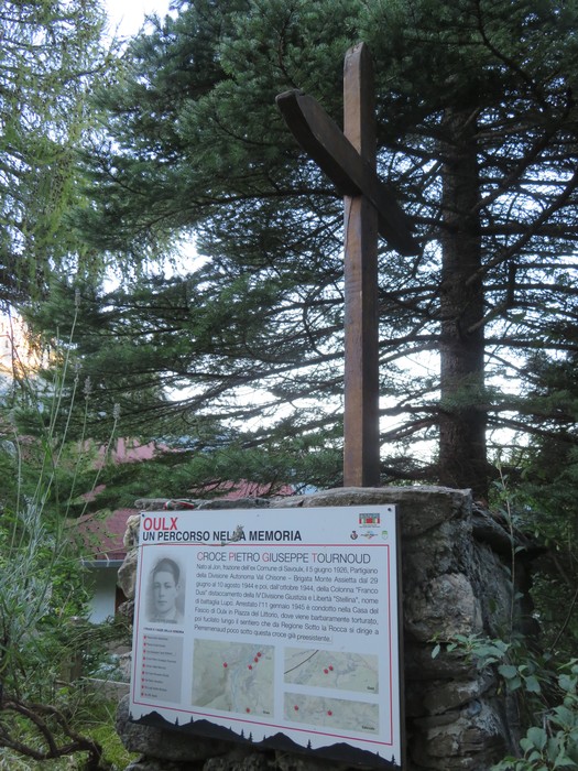 Croce a Tournoud, monumento dedicato alla memoria con pannello informativo, circondata da alberi.