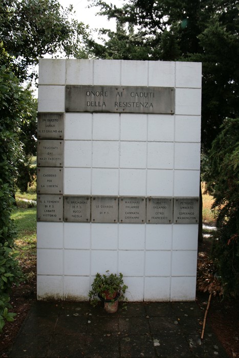 Monumento dedicato ai caduti della Resistenza, situato tra la vegetazione, in onore dei combattenti.