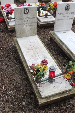 Tombe nel cimitero dedicate ai caduti per la Libertà, decorate con fiori e lumini.