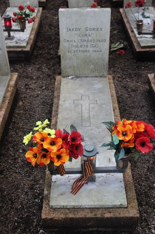 Tombe di caduti per la Libertà adornate con fiori colorati in un cimitero commemorativo.