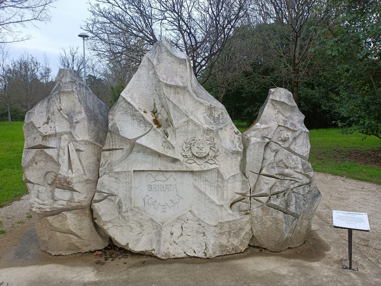 Monumento alla Brigata Maiella, scultura in pietra che commemora il coraggio dei soldati. Richiami di storia e memoria.