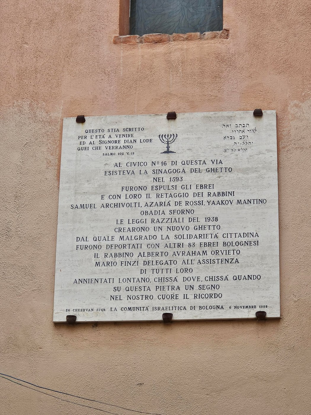 Lapide commemorativa in memoria degli ebrei deportati dal ghetto di Bologna, situata su un muro esterno.