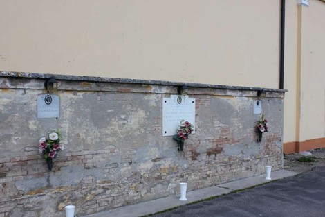 Lapidi in un muro di calce, con fiori e decorazioni, rappresentano la commemorazione a Calanca, Pecorari e Borghi.