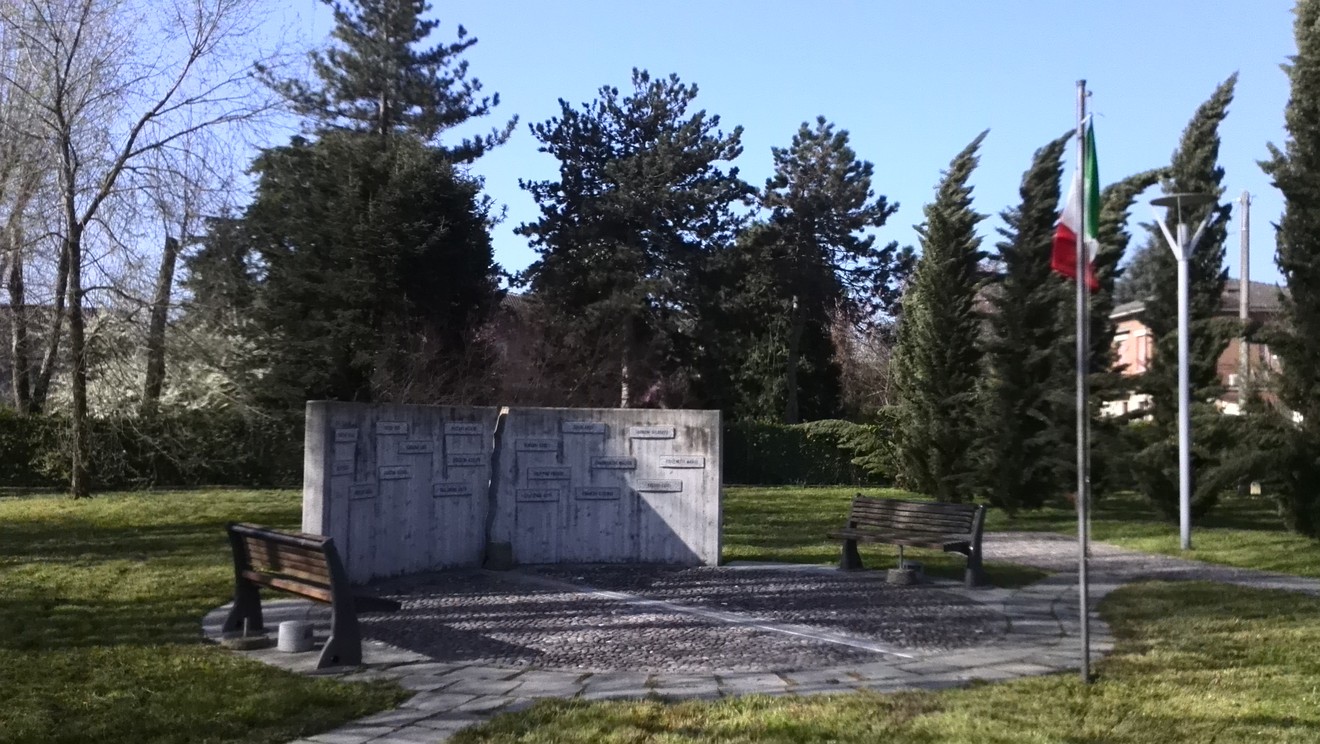 Monumento ai caduti della Liberazione di Villarotta, memoriale immerso nel verde con panchine e bandiera italiana.