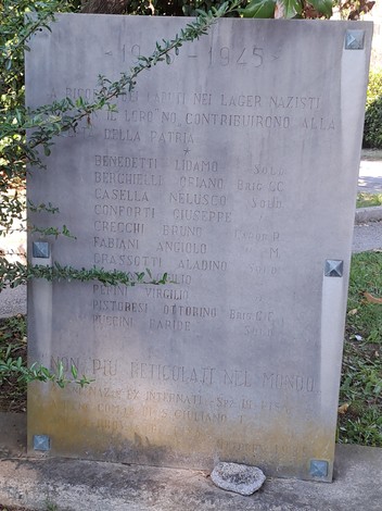 Stele commemorativa dedicata agli internati nei lager nazisti, con nomi e date incisi sulla pietra.