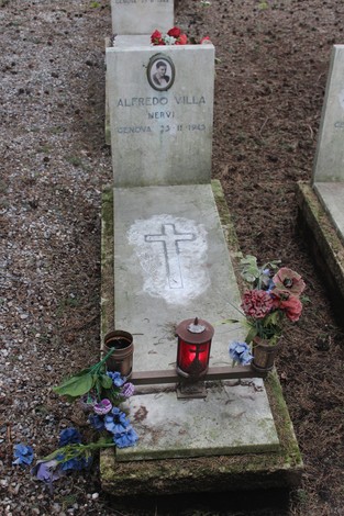 Tombe perpetue dedicate ai caduti per la Libertà, adornate con fiori e candele, in un cimitero tranquillo.