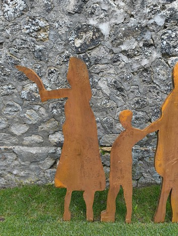 Silhouettes di figure umane che rappresentano un percorso, in contrasto con un muro di pietra naturale.