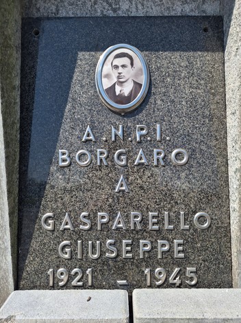 Cippo commemorativo in marmo dedicato a Giuseppe Gasparello con foto in ceramica e iscrizioni.