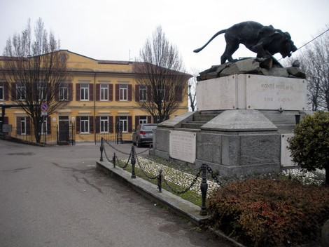 Monumento ai caduti di Montù Beccaria, con scultura di un felino e monumento commemorativo.