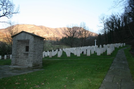 Cimitero di Guerra della valle del Santerno, circondato da un paesaggio montano e caratterizzato da numerose lapidi.