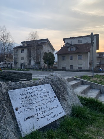 Lapide commemorativa dedicata a Don Carlo Prinetto, situata a Bussoleno, in ricordo del suo operato.