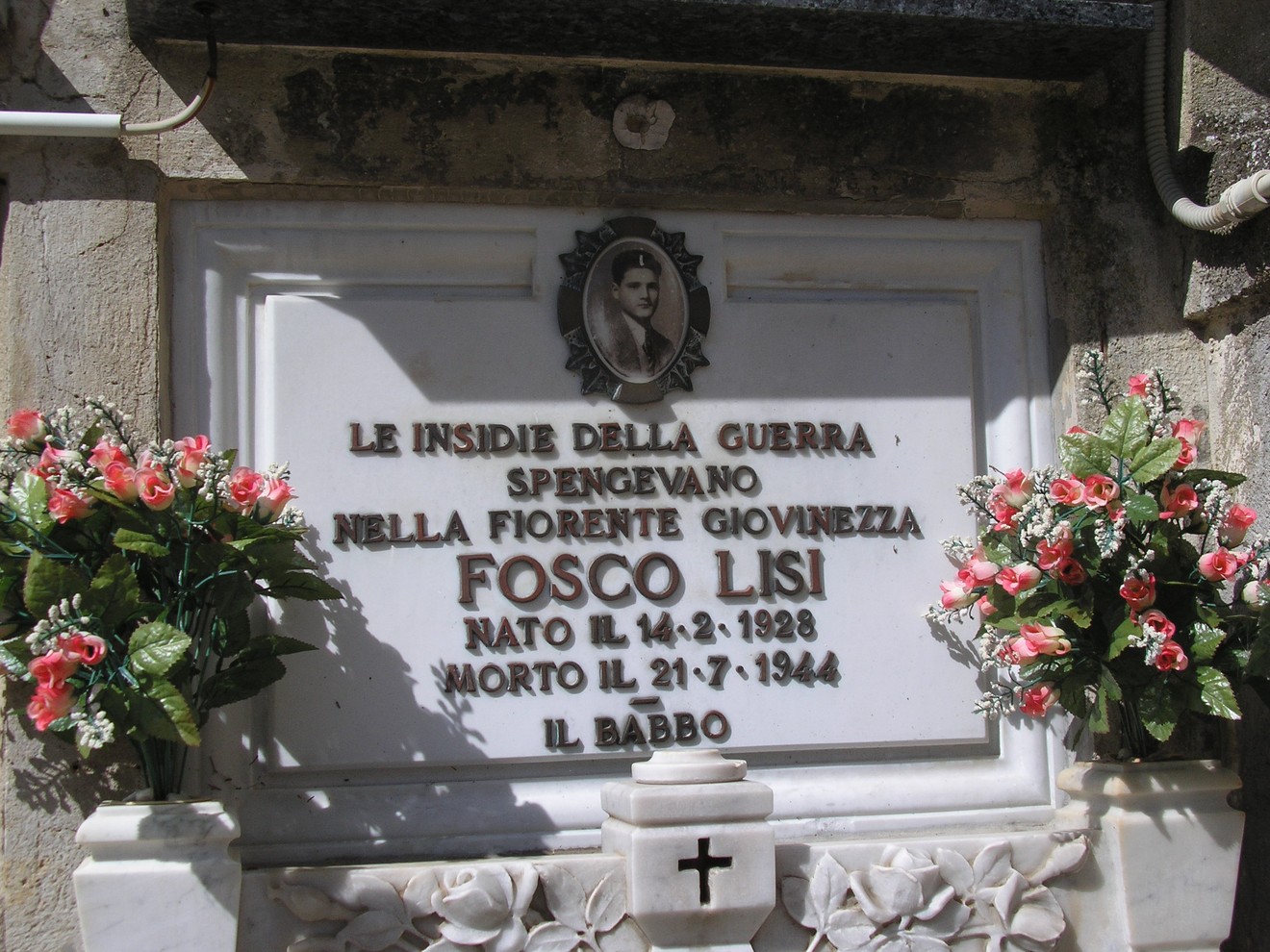 Sepolcro di Fosco Lisi, commemorativo di un giovane morto durante la guerra, con decorazioni floreali.
