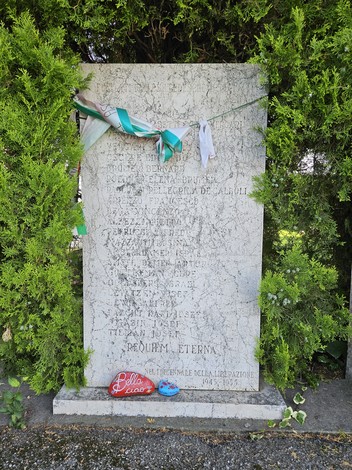 Monumento dedicato alle Vittime dell'eccidio dell'Aeroporto di Forlì, con decorazioni e un cuore rosso.