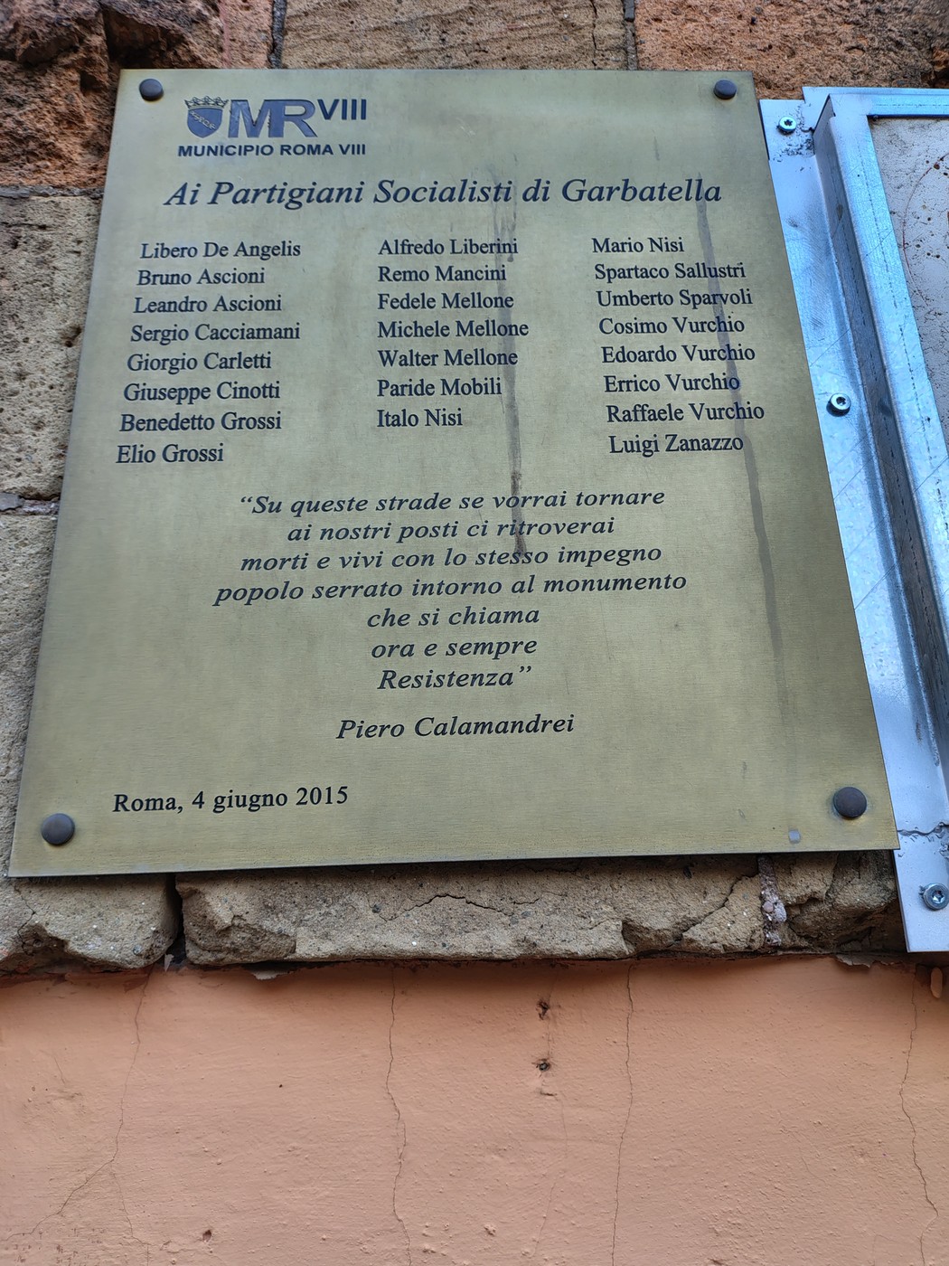 Targa commemorativa dedicata ai partigiani socialisti di Garbatella con nomi e un messaggio di resistenza.