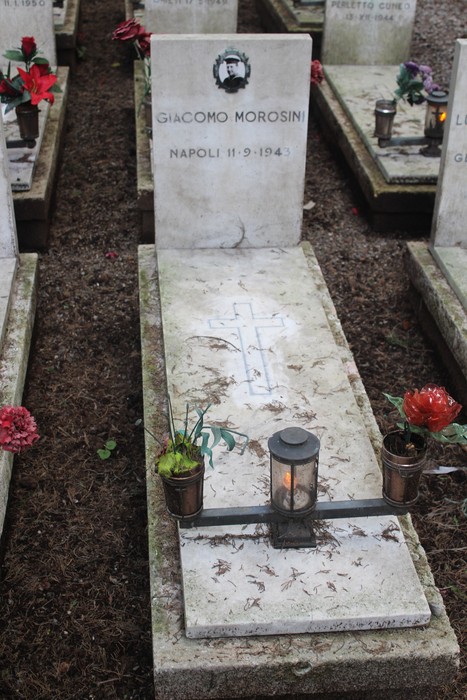 Tombe perpetue dei caduti per la Libertà con decorazioni floreali e lumini.