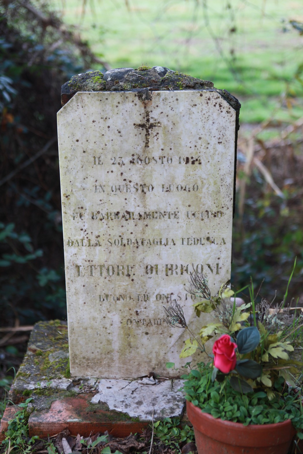 Cippo commemorativo a Quiriconi, dedicato ai caduti della Prima Guerra Mondiale, con decorazioni floreali.