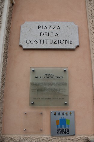 Piazza della Costituzione, con dettagli architettonici e pannelli informativi sulla sua storia e significato.