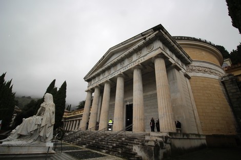 Lapide commemorativa di Gastaldi, con struttura architettonica classica e statue in un ambiente nebbioso.