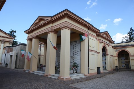 Vista del "Sacrario dei Caduti Partigiani", monumento commemorativo con colonne e decorazioni tricolori.