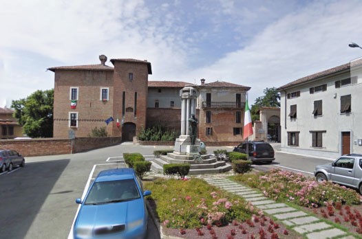 Monumento dedicato ai caduti, situato nella piazza di Lomello, circondato da edifici storici e verde pubblico.
