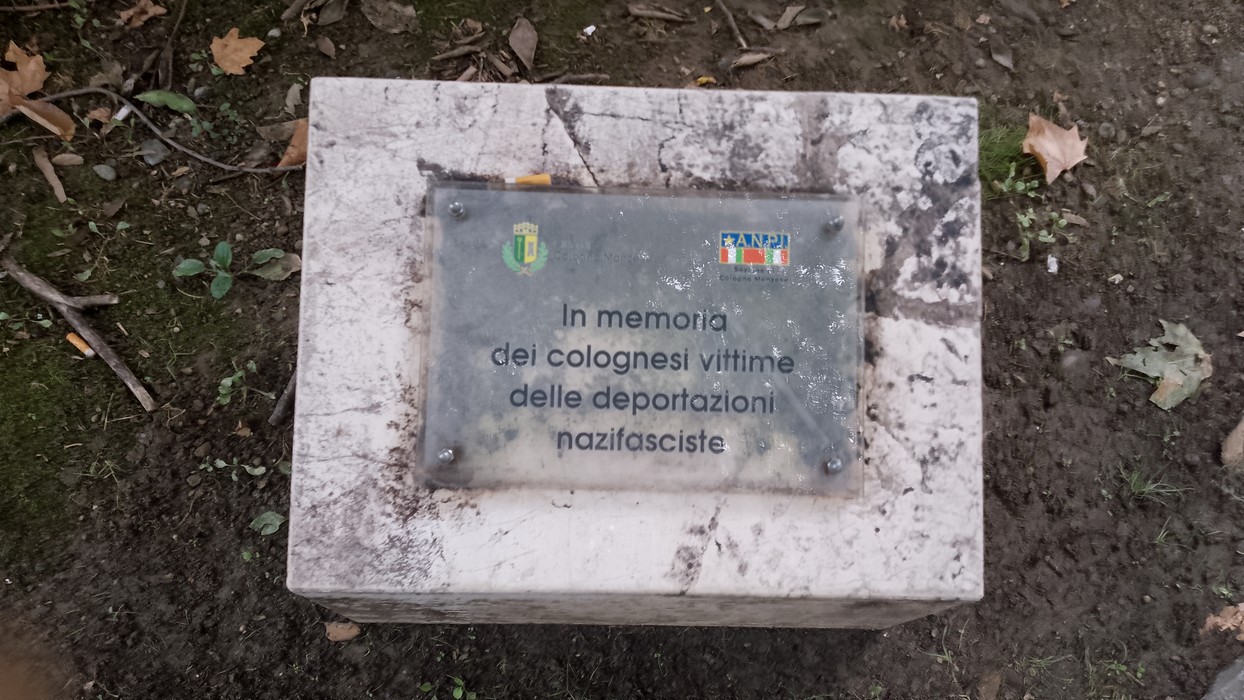 Cippo commemorativo dedicato ai colognesi vittime delle deportazioni nazifasciste, con simboli e scritte.