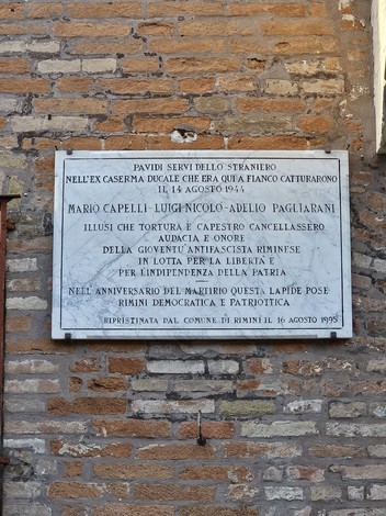 Lapide commemorativa dedicata ai Tre Martiri, con dettagli sulla loro cattura e eroismo.