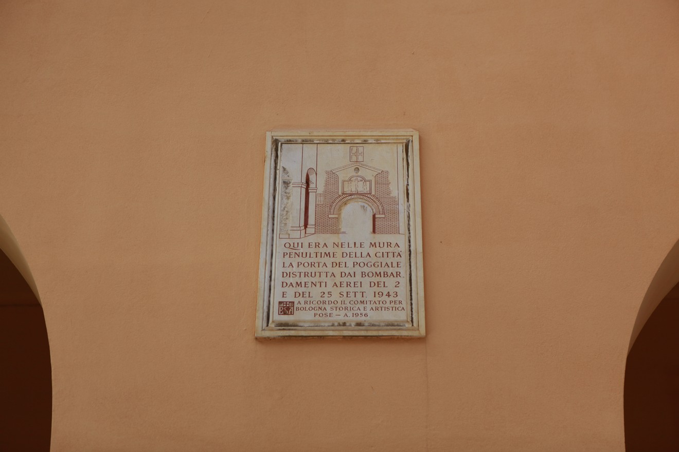 Lapide commemorativa affissa su un muro, dedicata alla Porta del Poggiale, con dettagli architettonici visibili.