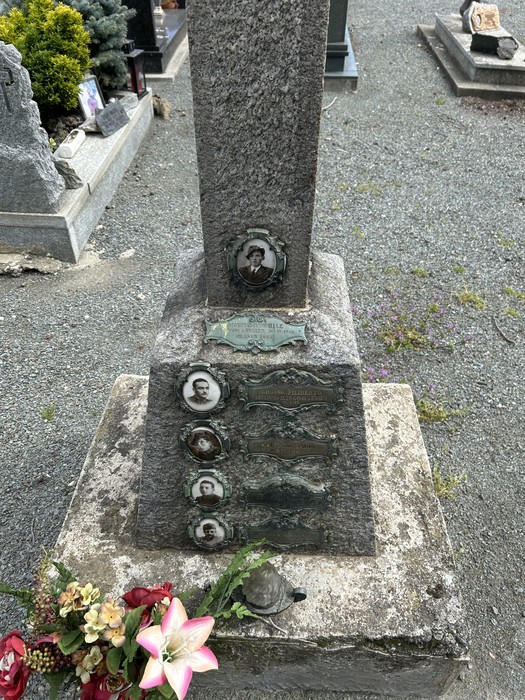 Croce commemorativa per gli internati militari, con foto e decorazioni, situata in un cimitero.