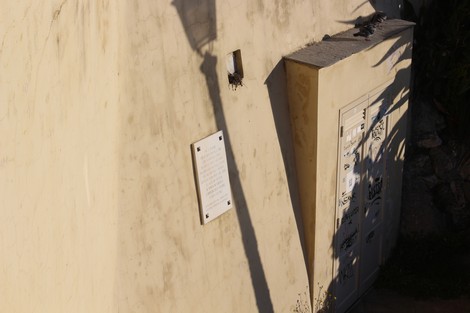 Lapide in memoria dei deportati, su un muro di un edificio affiancato da un cancello.