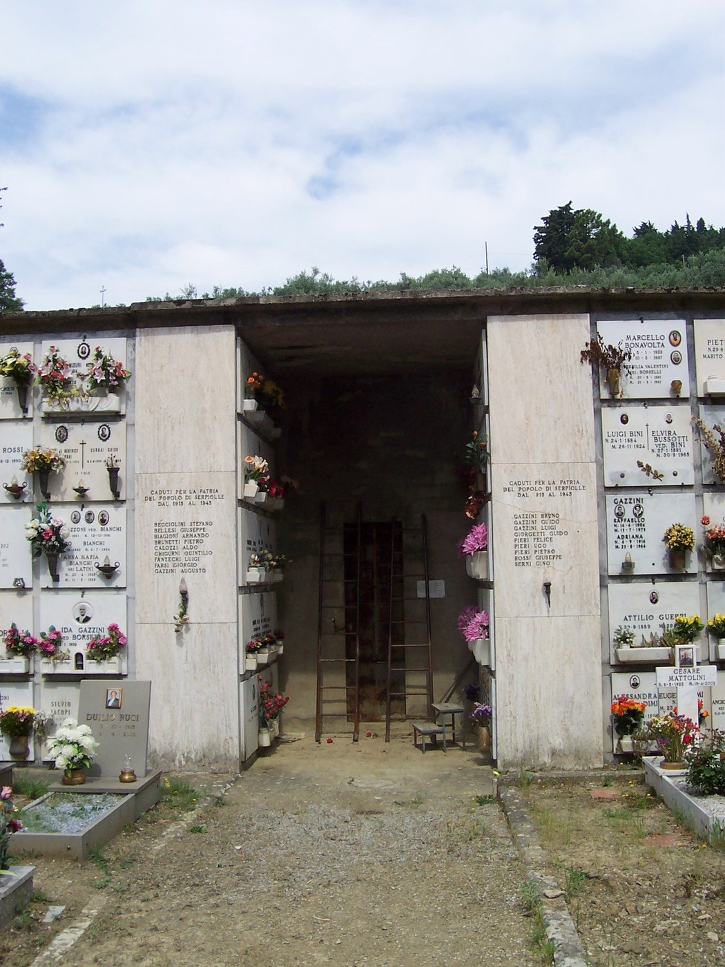 Lapidi commemorative dei caduti di Serpiolle, con fiori e decorazioni nel cimitero immerso nella quiete.