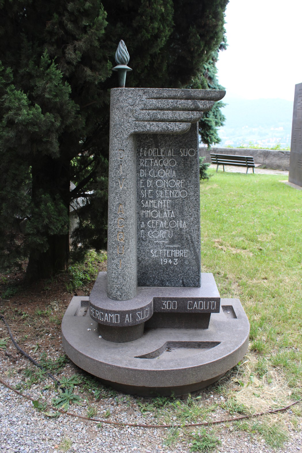 Monumento alla Divisione Acqui, dedicato ai caduti, con iscrizioni commemorative e una fiamma eterna.