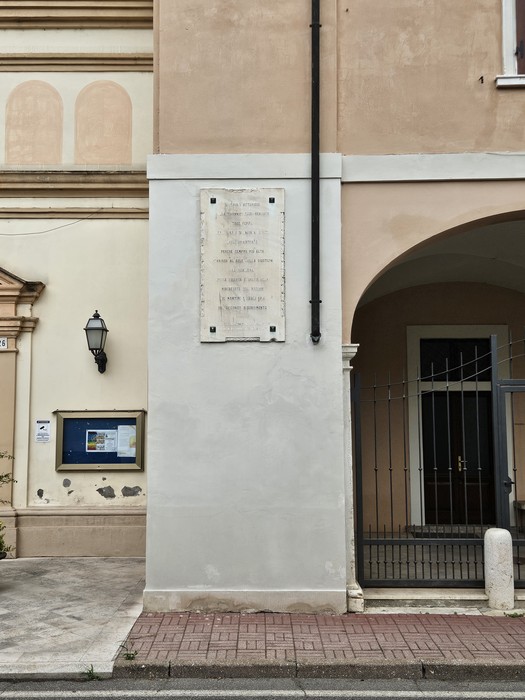 Lapide commemorativa dedicata alla Resistenza, posizionata su un edificio storico.