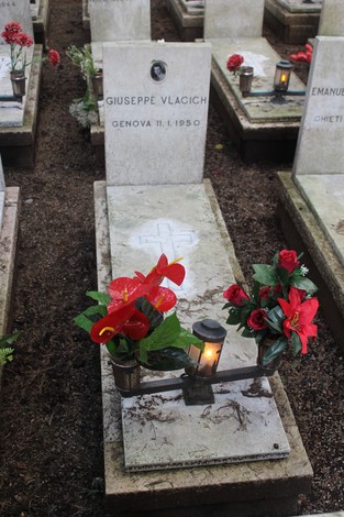 Tombe decorate con fiori su un cimitero, dedicate ai caduti per la Libertà. Atmosfera di rispetto e ricordo.